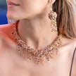 Close-up of a woman wearing a colorful beaded necklace and earrings.