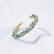Gold bracelet with blue stones on a white background