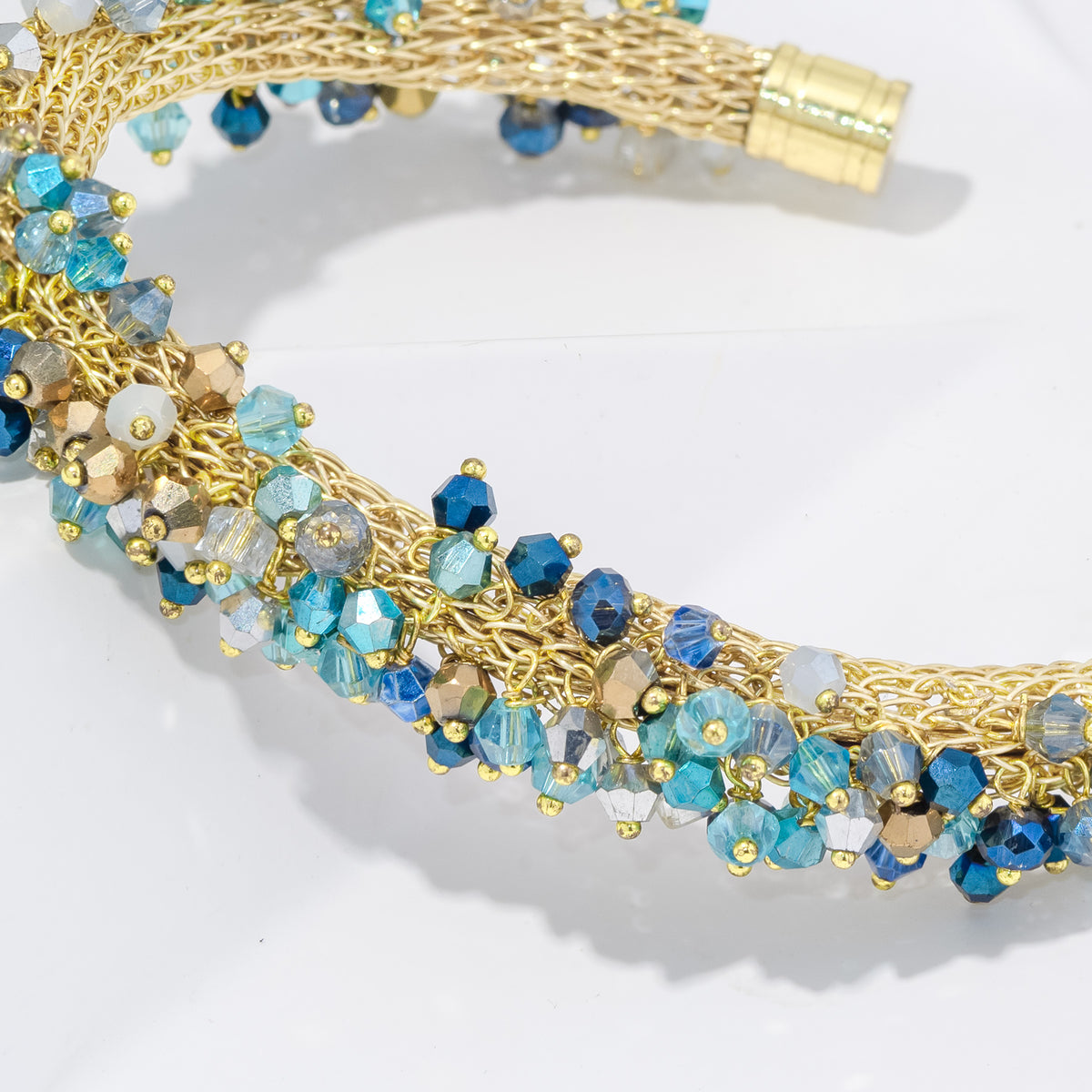 Gold and blue beaded necklace on a white background
