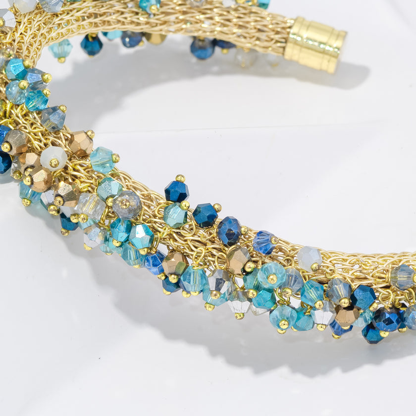 Gold and blue beaded necklace on a white background