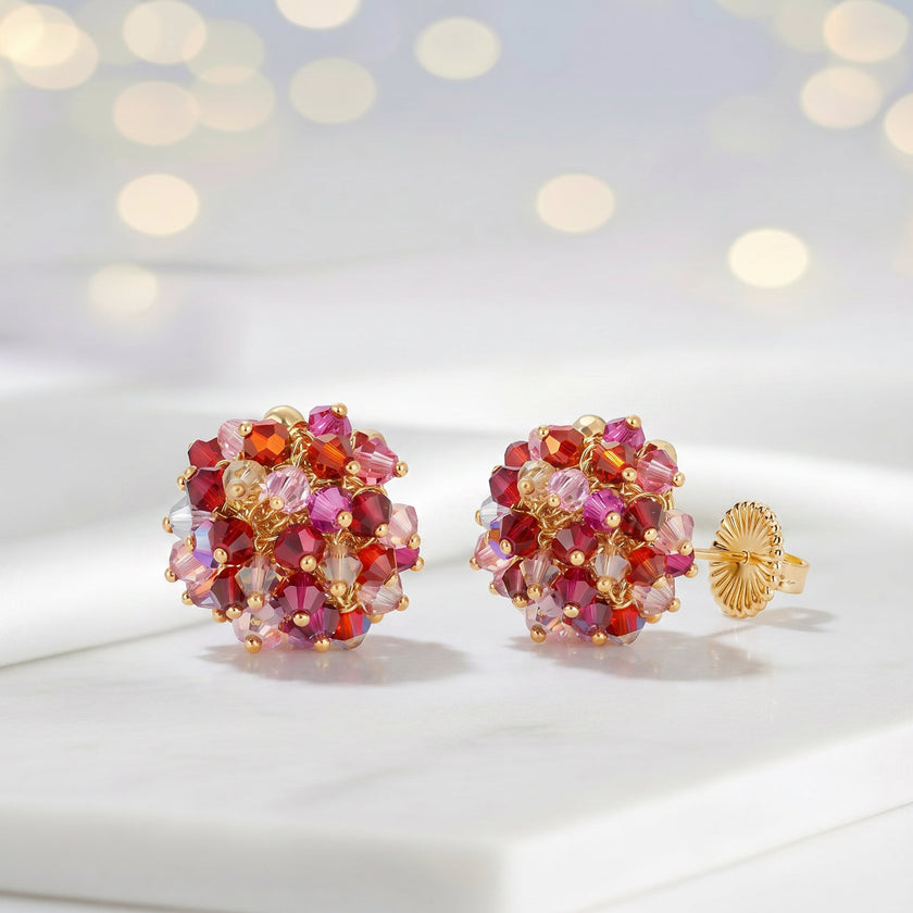 Gold cluster stud earrings with individually hanging crystals in shades of red and pink.