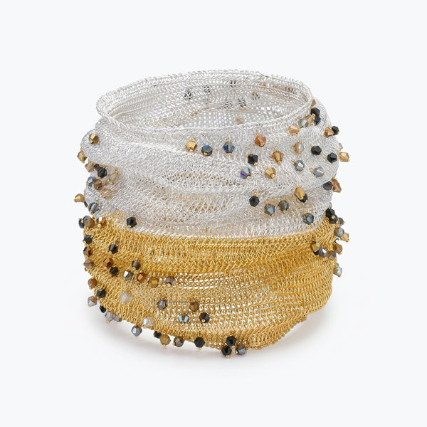Silver gold distorted cuff bracelet with a slender handknitted wire mesh adorned with bronze, jet hematite and silver premium crystals.
