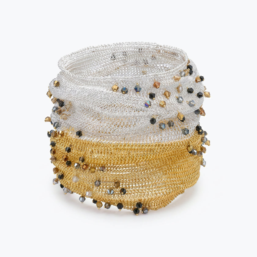 Silver gold distorted cuff bracelet with a slender handknitted wire mesh adorned with bronze, jet hematite and silver premium crystals.