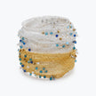 Silver gold distorted cuff bracelet with a slender handknitted wire pattern accented by light blue and silver reflective crystals.