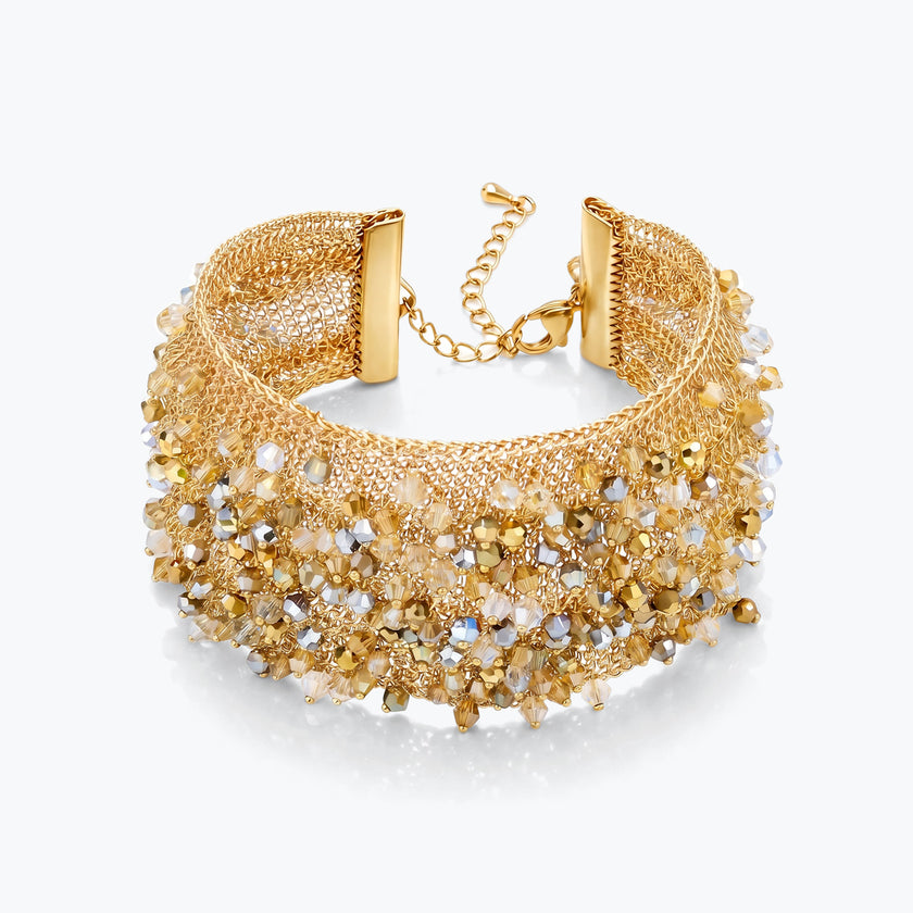 Gold cuff bracelet displaying a textured handknitted wire mesh band with clear and champagne reflective crystals.