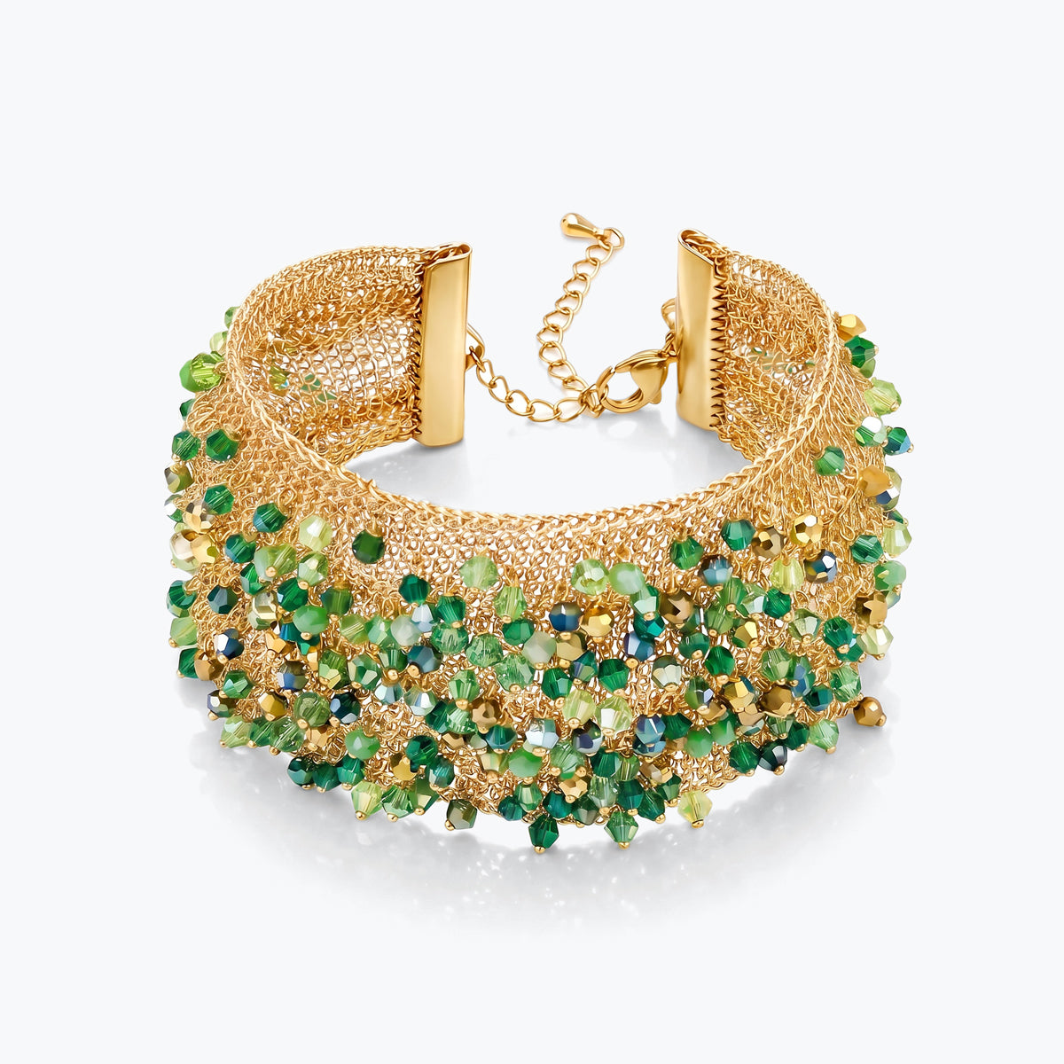 Gold cuff bracelet featuring a textured handknitted wire band studded with emerald green premium crystals.