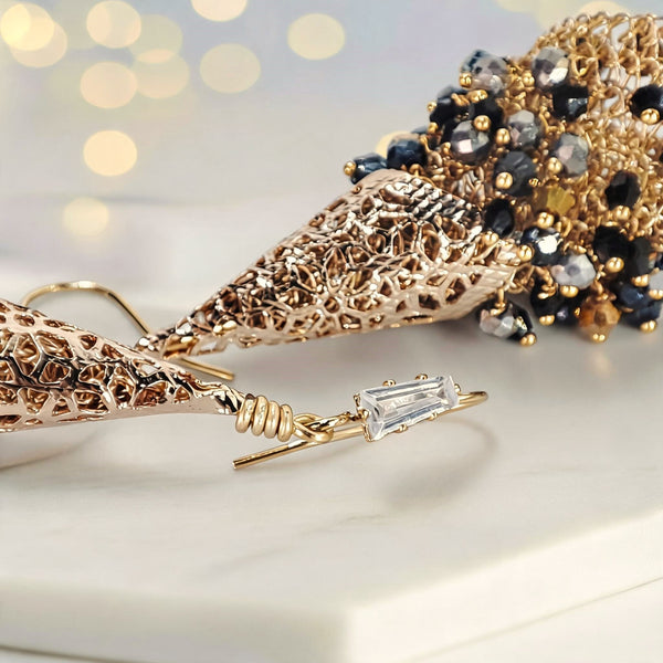 Gold drop earrings composed of handknitted wire cone and individually hanging gunmetal, bronze, and black premium crystals.