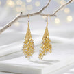 Gold drop earrings with a handknitted wire cone and a cascade of individually hanging champagne, gold and silver reflective crystals.