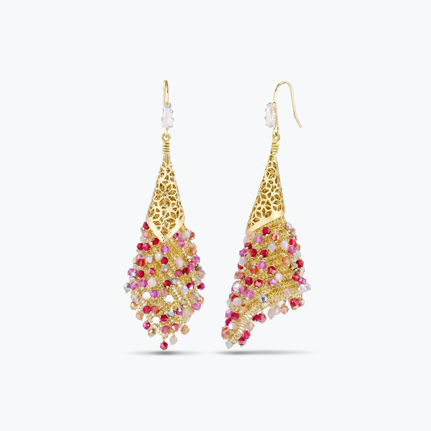 Gold drop earrings showcasing a handknitted wire cone structure filled with individually hanging pink and red crystals.