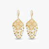 Gold drop earrings featuring a diamond-patterned handknitted wire square panel and tiered strands of premium gold crystals.
