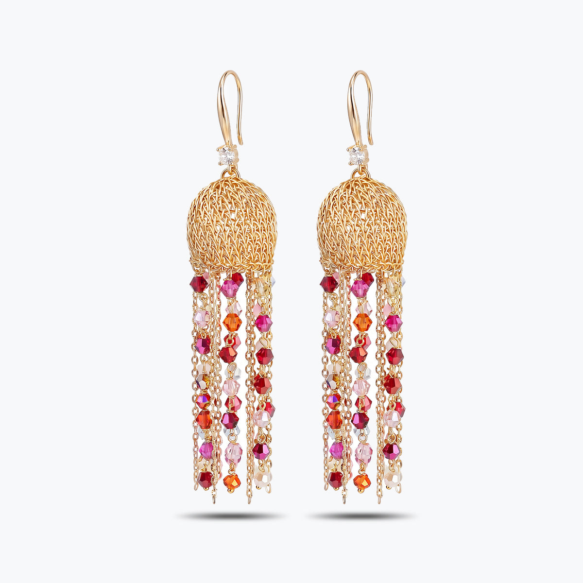 Gold drop earrings with a handknitted wire sphere and elegant linear tassel strands of vibrant red crystals.