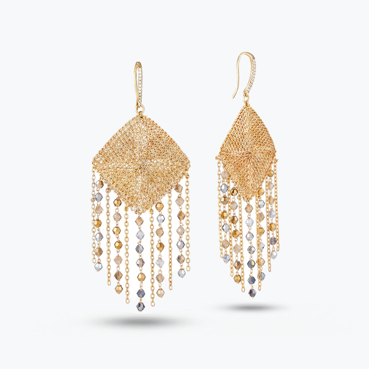 Gold drop earrings displaying a teardrop handknitted wire mesh rhombus panel and hanging clear and champagne premium crystals.