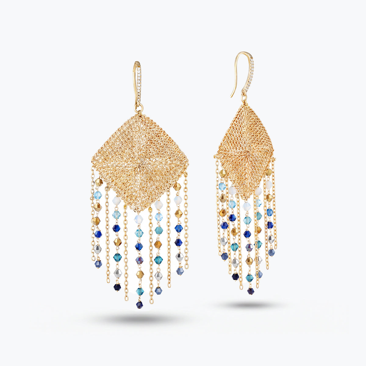 Gold drop earrings featuring a handknitted wire mesh rhombus panel frame and cascading blue and gray reflective crystals.