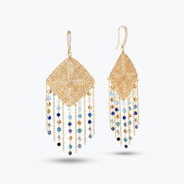 Gold drop earrings featuring a handknitted wire mesh rhombus panel frame and cascading blue and gray reflective crystals.