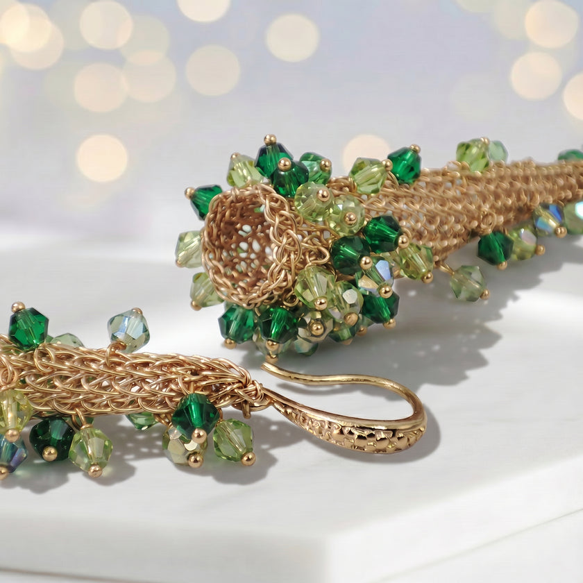 Conical earrings made of handknitted wire mesh featuring reflective crystals in shades of green and gold.