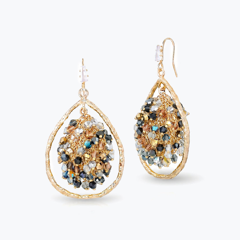 Gold drop earrings showing a handknitted wire mesh teardrop shape with hanging gunmetal and bronze reflective crystals.