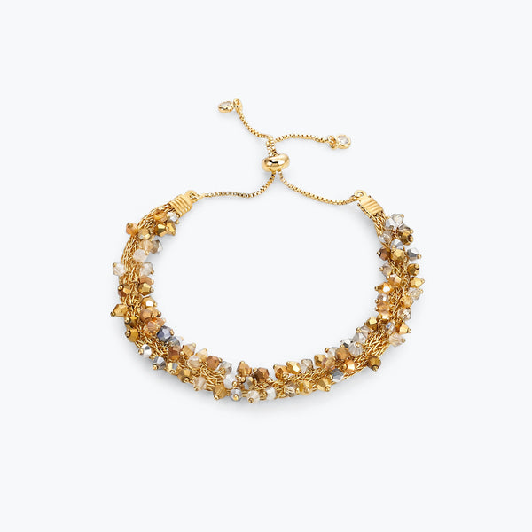 Gold handknitted wire slider bracelet with reflective crystals in champagne, gold, silver, and clear tones.