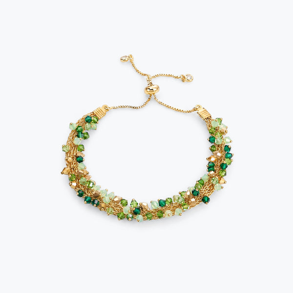Gold handknitted wire slider bracelet displaying green, emerald, mint, and gold premium crystals.
