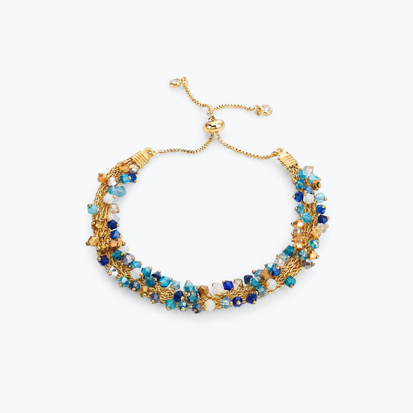 Gold handknitted wire slider bracelet featuring blue, turquoise, aqua, and bronze premium crystals.