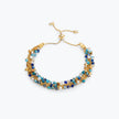 Gold handknitted wire slider bracelet featuring blue, turquoise, aqua, and bronze premium crystals.