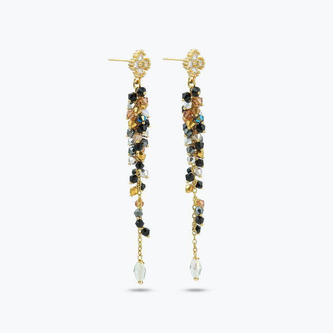 Gold drop earrings displaying a sleek handknitted wire vertical frame decorated with gray and black premium crystals.
