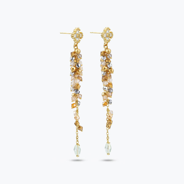 Gold drop earrings featuring a long linear handknitted wire design with hanging champagne and clear premium crystals.
