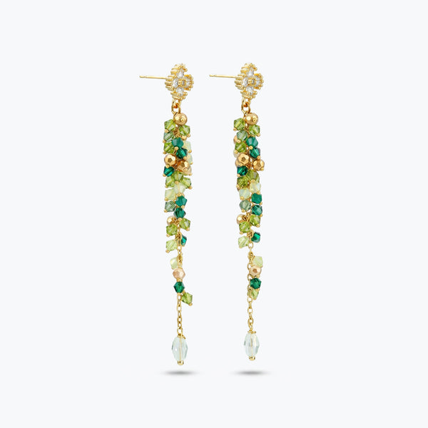 Gold drop earrings with a vertical handknitted wire mesh strip trailing down into green individually hanging crystals.
