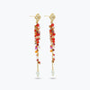 Gold drop earrings featuring an elongated handknitted wire mesh bar holding individually hanging pink and red crystals.
