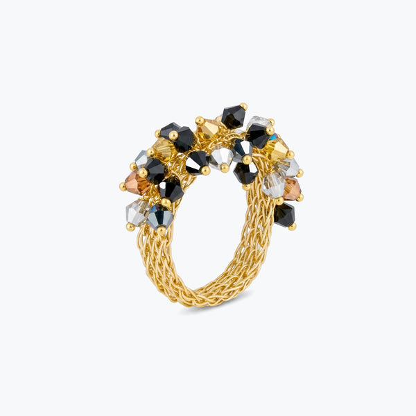 Gold band ring with a cluster of black, silver, and bronze reflective crystals on handknitted wire.