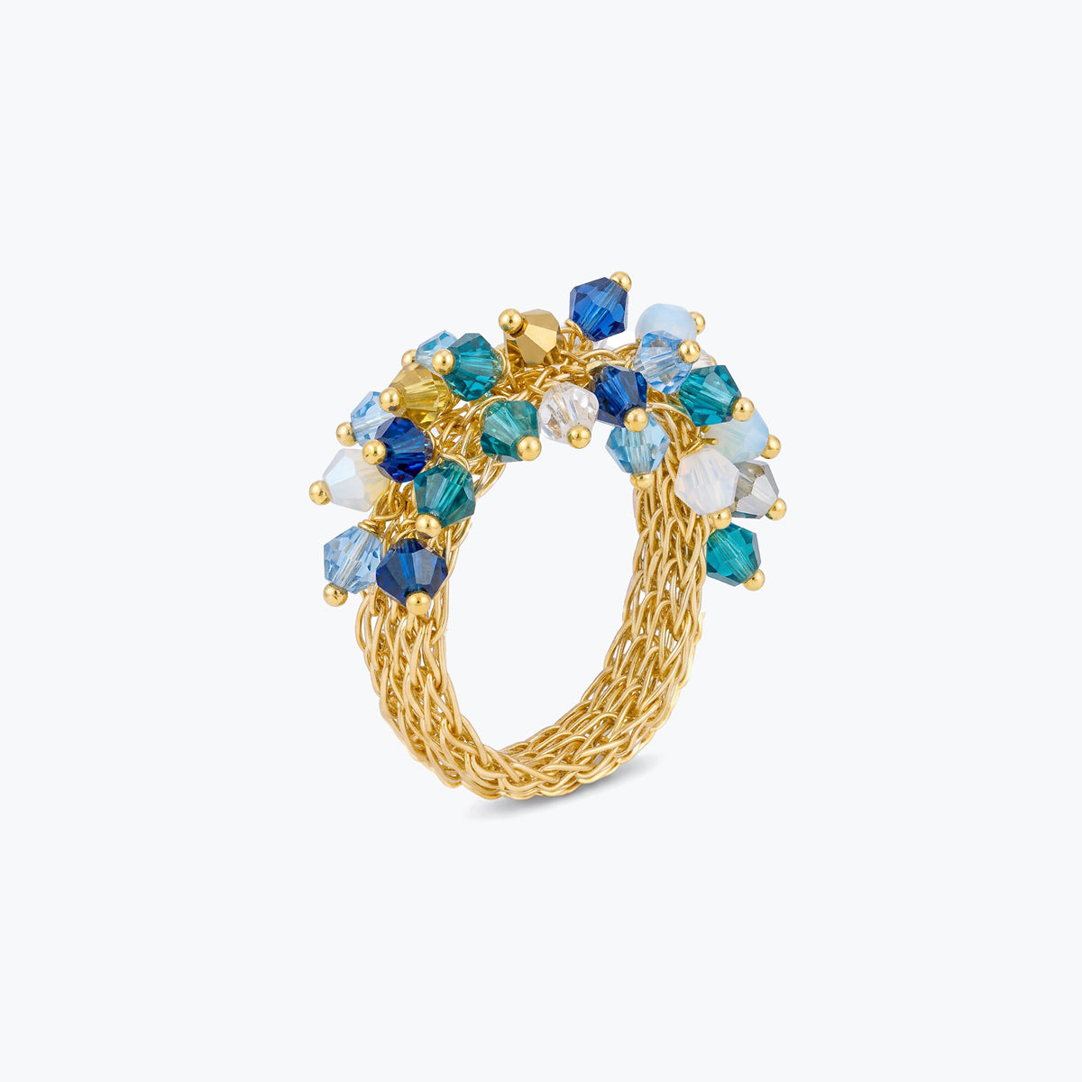 Gold statement ring featuring premium crystals in shades of blue and aqua on handknitted wire mesh.