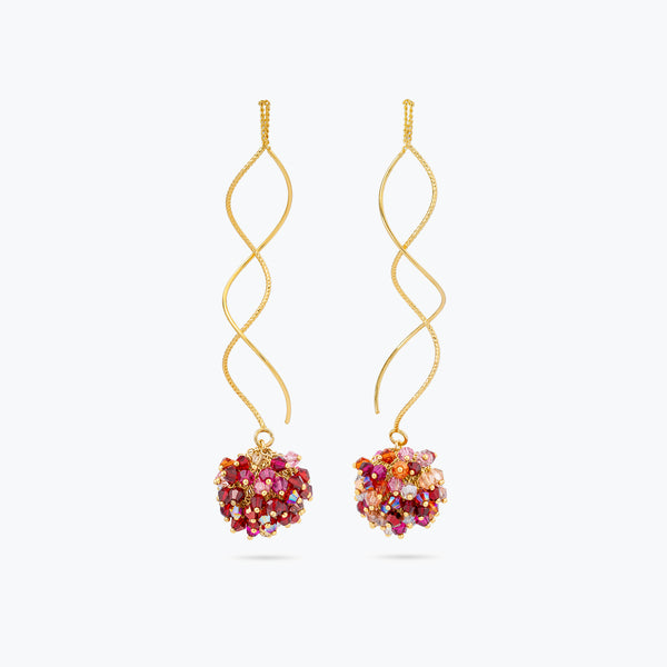 Gold spiral drop earrings with a rounded bunch of premium crystals in red, pink, and orange tones.
