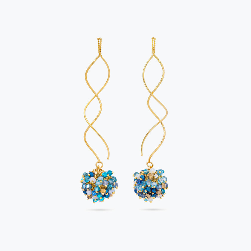 Gold spiral drop earrings with a cluster of individually hanging crystals in various shades of blue.