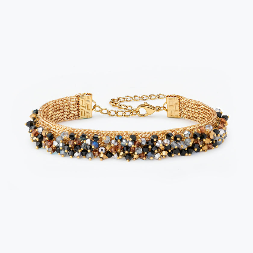Gold handknitted wire mesh bracelet embellished with reflective crystals in black, bronze, and silver.