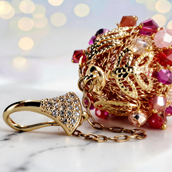 Long gold drop earrings featuring a handknitted wire mesh pod tightly packed with red and pink premium crystals.