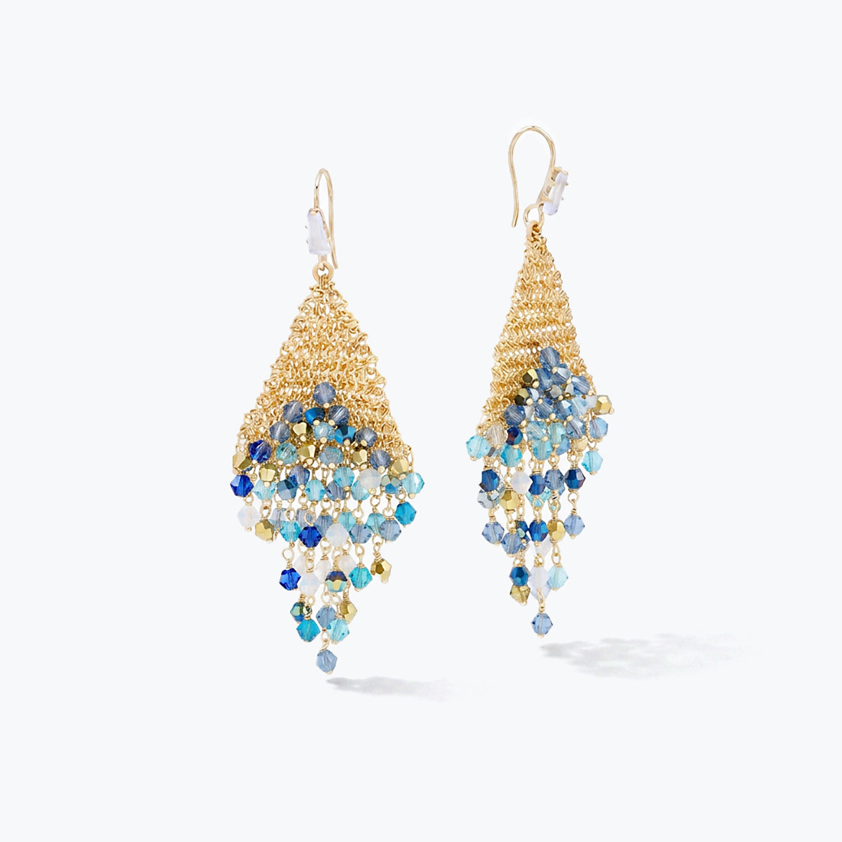 Gold drop earrings featuring a handknitted wire triangle shape accented by cascading blue and silver premium crystals.