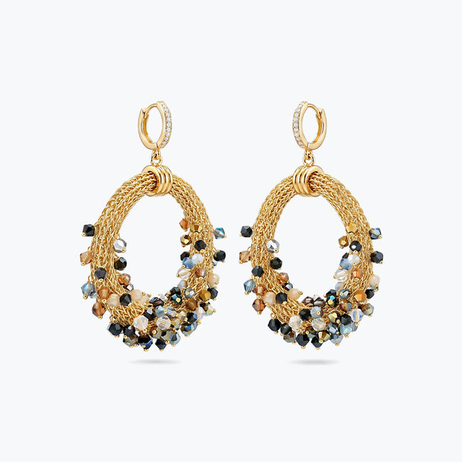 Gold loop earrings featuring a crescent handknitted wire outline and individually hanging black and bronze crystals.