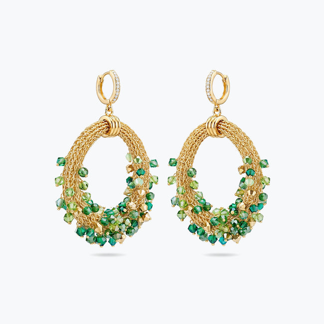 Gold loop earrings displaying a curved crescent handknitted wire mesh frame filled with hanging green premium crystals.