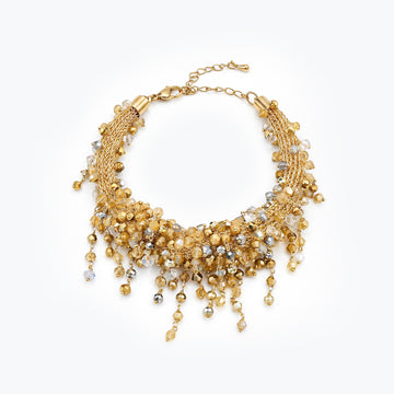 Gold bracelet featuring an openwork handknitted wire embedded with clear and champagne premium hanging crystals.