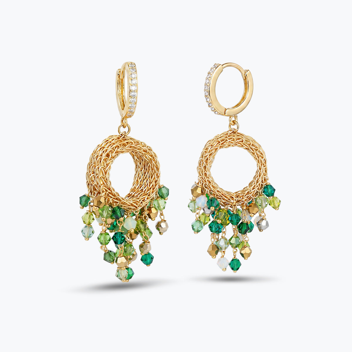 Gold hoop earrings with handknitted wire mesh detailing and reflective hanging crystals in emerald and green.