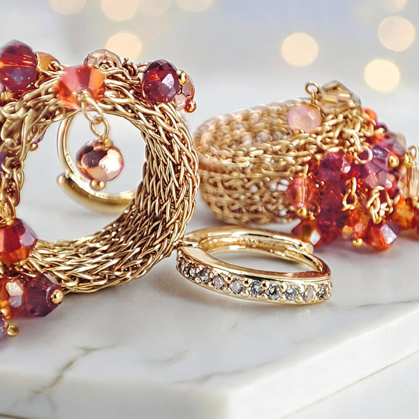 Gold wire hoop earrings showcasing multi-tonal premium hanging crystals in vibrant ruby red, pink hues.