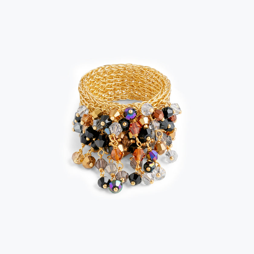 Wide handknitted wire gold ring fringed with black, silver, and bronze reflective crystals.