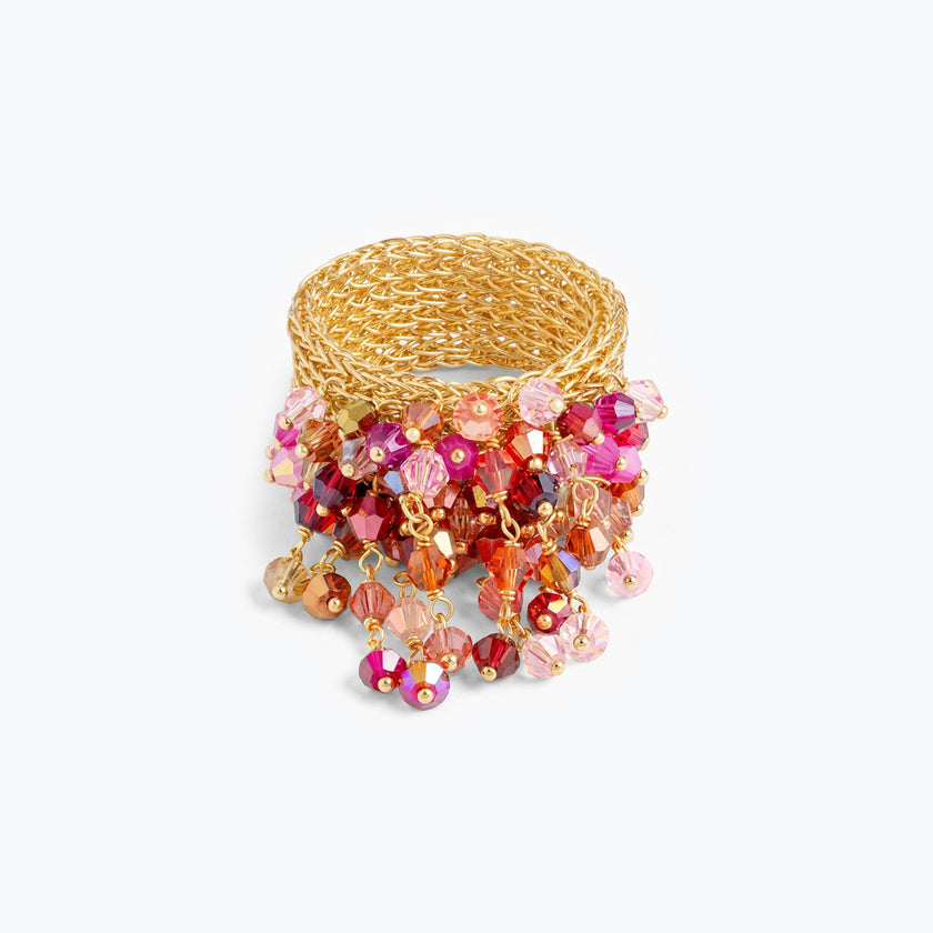 Wide gold mesh band ring featuring individually hanging crystals in magenta, red, and pink hues.