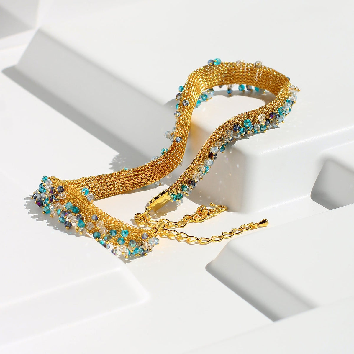 Gold necklace with gemstones on a white background