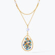 Gold handknitted tear drop wire mesh pendant necklace featuring a crescent bib design with blue and aqua premium crystals.