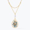 Gold handknitted tear drop wire mesh pendant necklace featuring a crescent bib design with blue and aqua premium crystals.