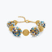 Gold bracelet featuring 9 ball handknitted wire accented by light blue and sapphire crystals.