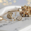 Gold drop earrings featuring an egg handknitted wire mesh base with hanging clear and champagne premium crystals.
