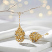 Gold drop earrings featuring an egg handknitted wire mesh base with hanging clear and champagne premium crystals.