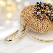 Gold handknitted wire mesh hoop earrings with reflective crystals in bronze, black, and metallic silver.