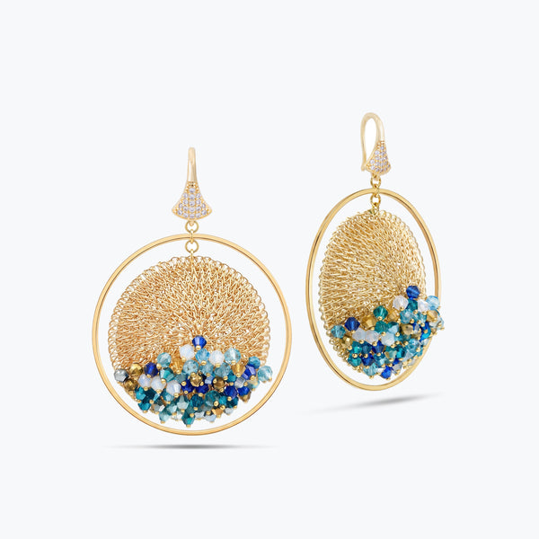 Gold handknitted wire hoop earrings featuring individually hanging blue, turquoise, and white premium crystals.